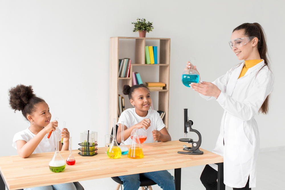 The Doctor teaching two young students how to test using the microscope